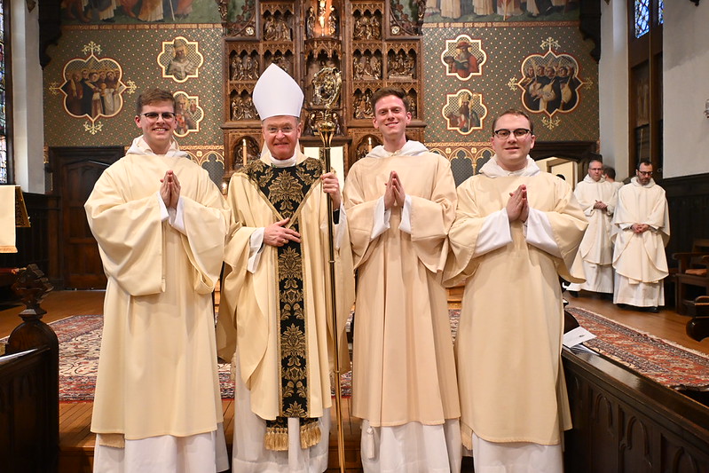 Three Dominican friars newly ordained as deacons stand together following the ordination rite.